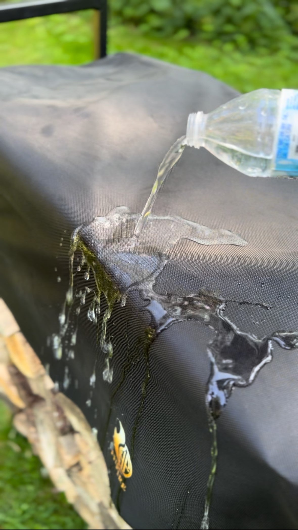 Water proof firewood rack cover with water droplets visible